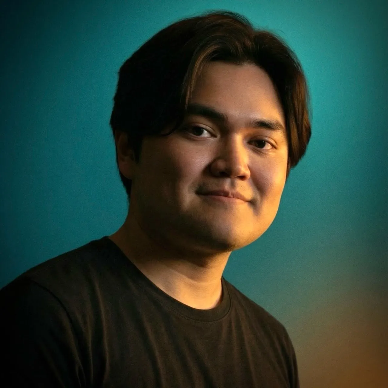 Portrait photograph of Jericho Mendoza against a textured teal and warm cream background.